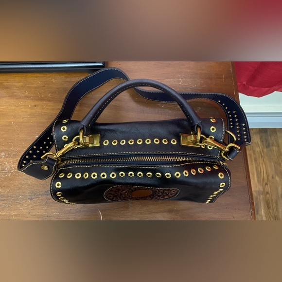 Black leather cross body purse with orange colored medallion on front. - Picture 5 of 14